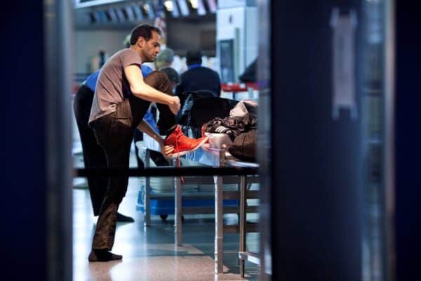 Photo: A traveler takes off his shoes before passing through a security control point at the John F. Kennedy airport in New York